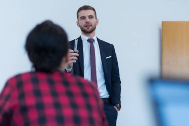 Bir grup insan sunum konuşmasını dinliyor ve yaratıcı ofiste birlikte çalışıyor ve iletişim kuruyorlar.