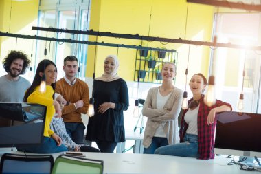 Çok ırklı genç iş adamları yeni projelerinde başarılı olduktan sonra fotoşoplama yapıyorlar...