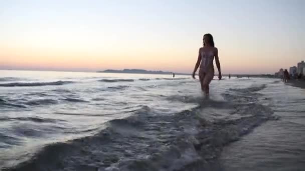 Женщина в бикини бегает по пляжу — стоковое видео