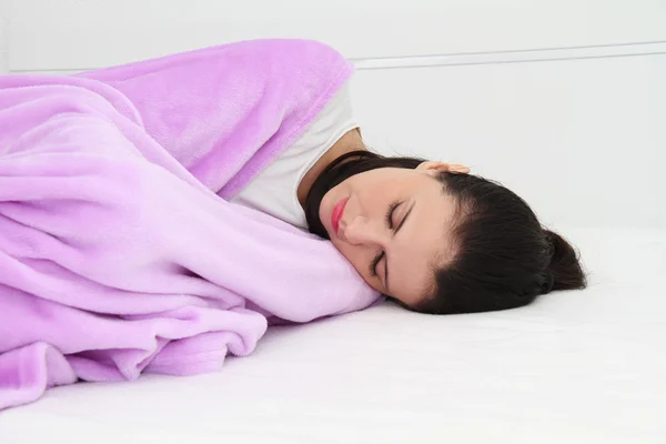 Atractiva joven mujer durmiendo en la cama con el ordenador portátil — Foto de Stock