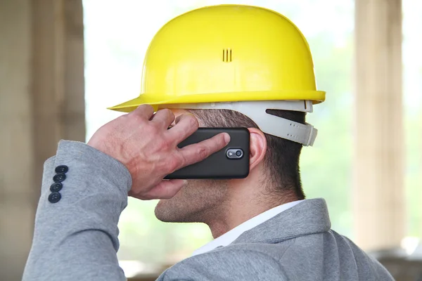 Engineer at a construction site making a business call — Stock Photo, Image