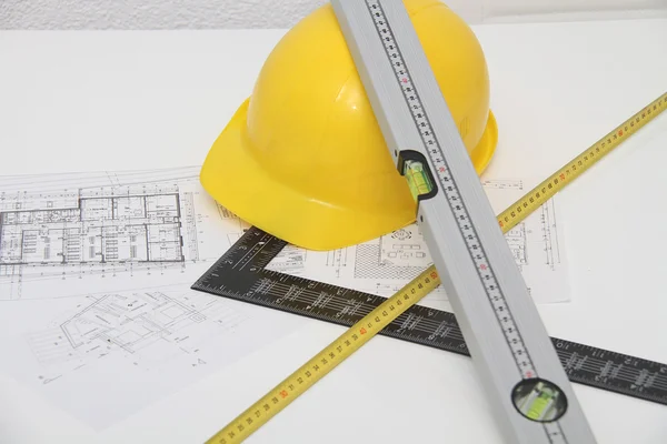 Helmet and tools for construction drawings and buildings — Stock Photo, Image