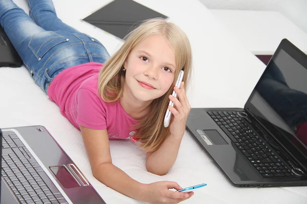 Małe dziecko w domu grając z tabletki, laptop i telefon — Zdjęcie stockowe