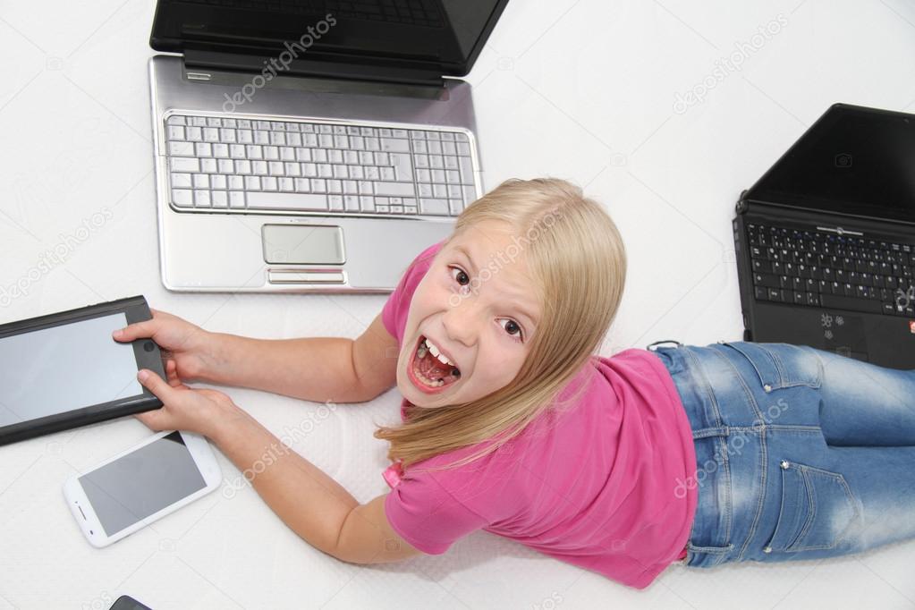 Little child playing at home with tablet, laptop and phone