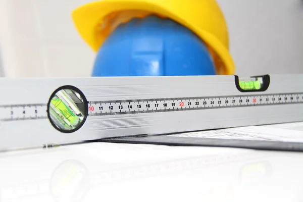 Helmets and tools for construction drawings and buildings — Stock Photo, Image