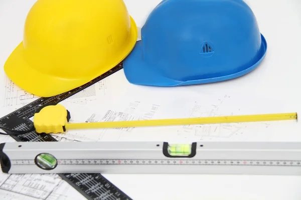 Helmets and tools for construction drawings and buildings — Stock Photo, Image