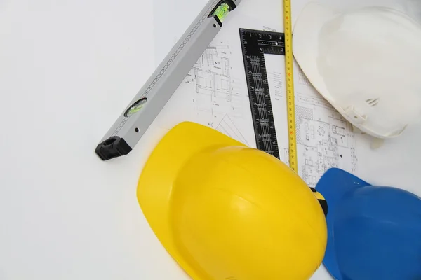 Helmets and tools for construction drawings and buildings — Stock Photo, Image