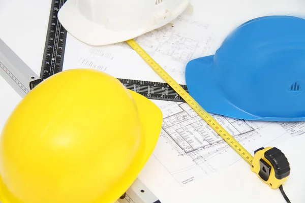 Helmets and tools for construction drawings and buildings — Stock Photo, Image