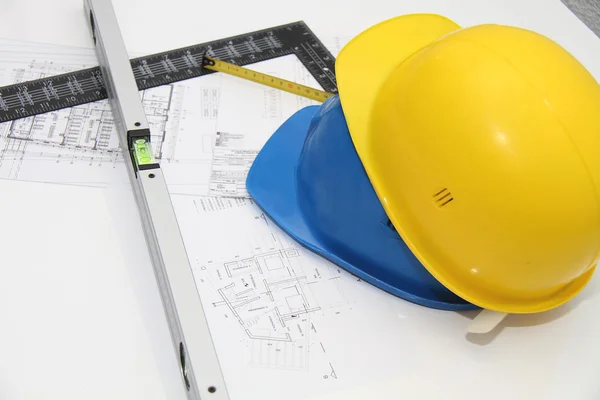 Helmets and tools for construction drawings and buildings Stock Photo
