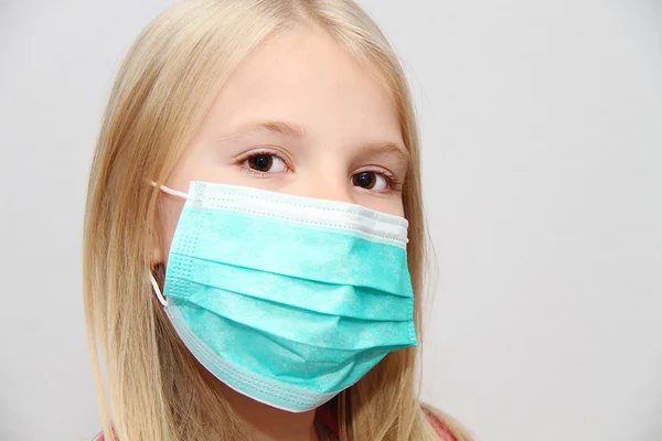 Koruyucu maske takan küçük bir kız.
