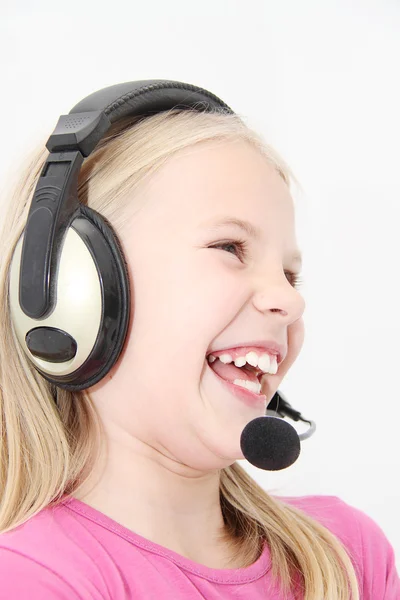 Cute little girl is enjoying music using headphones — Stock Photo, Image