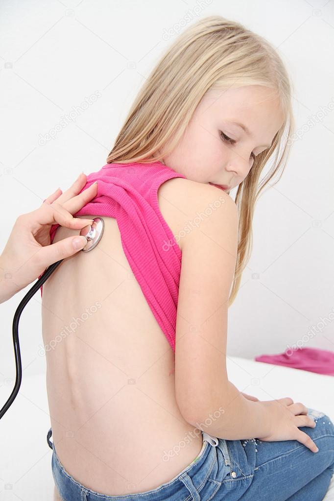 Little girl being listened by a doctor