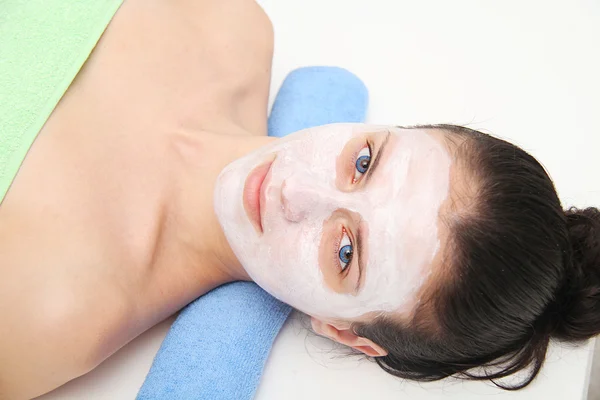 Beautiful young blue eye woman with clay facial mask — Stock Photo, Image