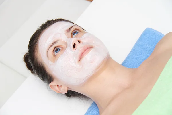 Beautiful young blue eye woman with clay facial mask — Stock Photo, Image