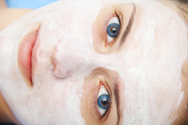 Beautiful young blue eye woman with clay facial mask — Stock Photo, Image