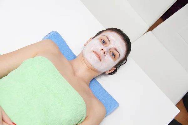 Beautiful young blue eye woman with clay facial mask — Stock Photo, Image