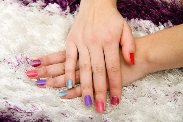 Mãos de mulher com unhas coloridas — Fotografia de Stock