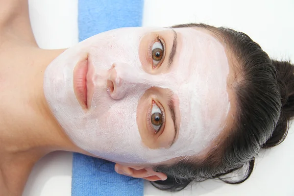 Beautiful young blue eye woman with clay facial mask — Stock Photo, Image