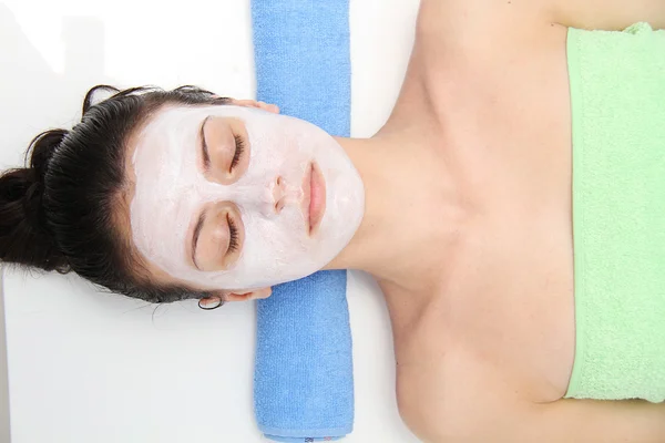 Beautiful young blue eye woman with clay facial mask — Stock Photo, Image