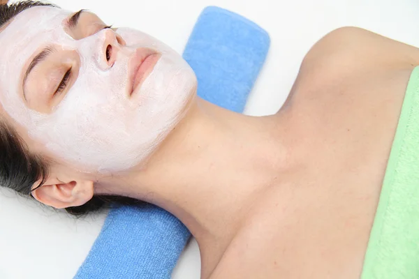 Beautiful young blue eye woman with clay facial mask — Stock Photo, Image