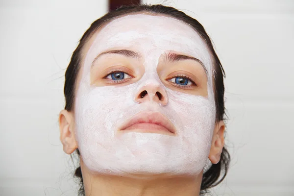 Beautiful young blue eye woman with clay facial mask — Stock Photo, Image