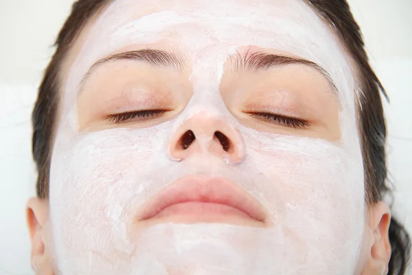 Beautiful young blue eye woman with clay facial mask — Stock Photo, Image