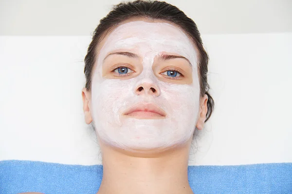 Vackra unga blå öga kvinna med lera ansiktsmask — Stockfoto