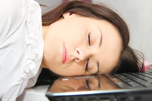 Tired business woman fell asleep next to a laptop