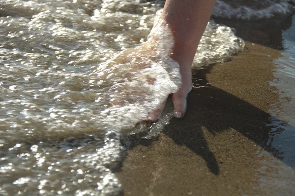 La mano de la mujer tocando el agua del mar — Foto de Stock