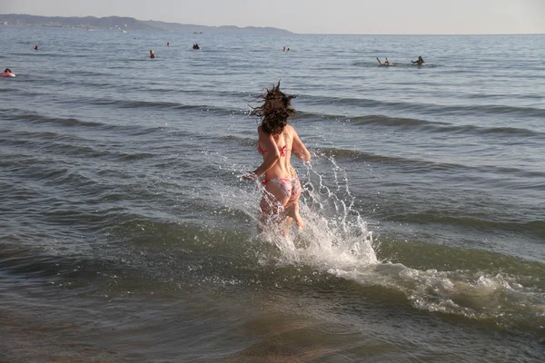 Młoda atrakcyjna kobieta, biegnącej wzdłuż brzegu morza — Zdjęcie stockowe