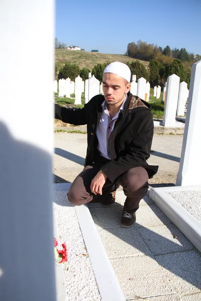 Jeune homme musulman près de la tombe de son père — Photo