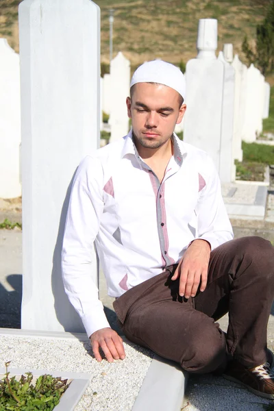 Junger muslimischer Mann nahe dem Grab seines Vaters — Stockfoto