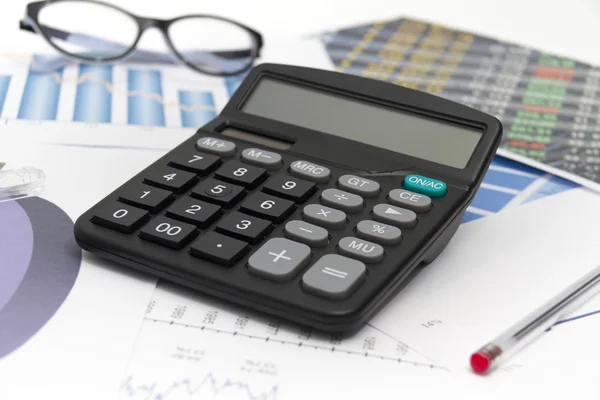 Homme d'affaires analysant les graphiques d'investissement avec calculatrice et lapt — Photo