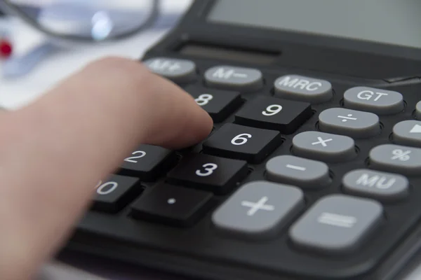 Бізнесмен аналізує інвестиційні карти з калькулятором і ноутбуком — стокове фото