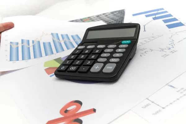 Businessman analyzing investment charts with calculator and lapt — Stock Photo, Image