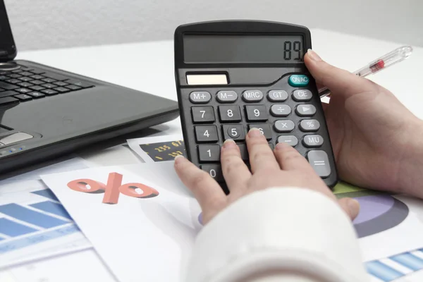 Jovem empresária calculando documentos financeiros — Fotografia de Stock