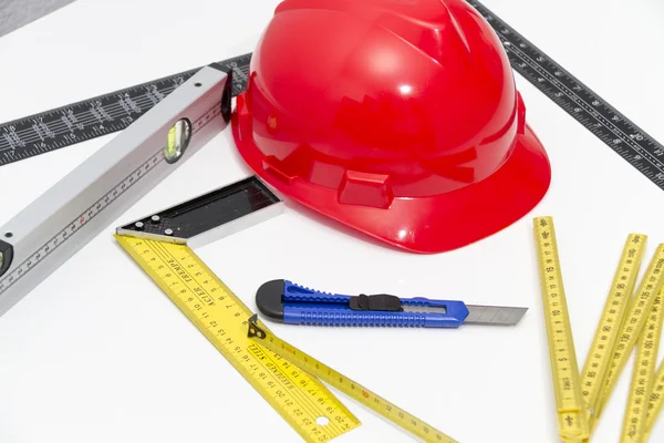 Helmet and tools for construction drawings and buildings — Stock Photo, Image