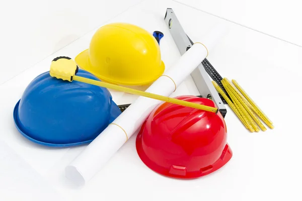 Colorful helmets and tools for construction drawings and buildin — Stock Photo, Image