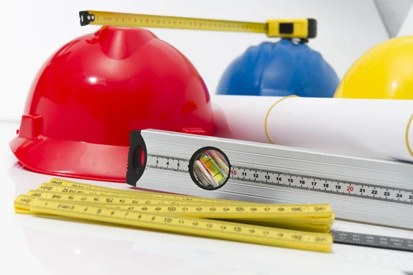 Colorful helmets and tools for construction drawings and buildin — Stock Photo, Image