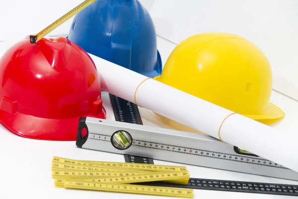 Colorful helmets and tools for construction drawings and buildin — Stock Photo, Image