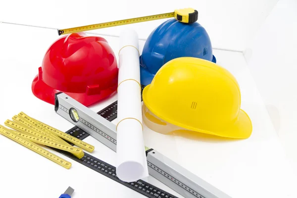 Cascos coloridos y herramientas para los dibujos de construcción y buildin —  Fotos de Stock