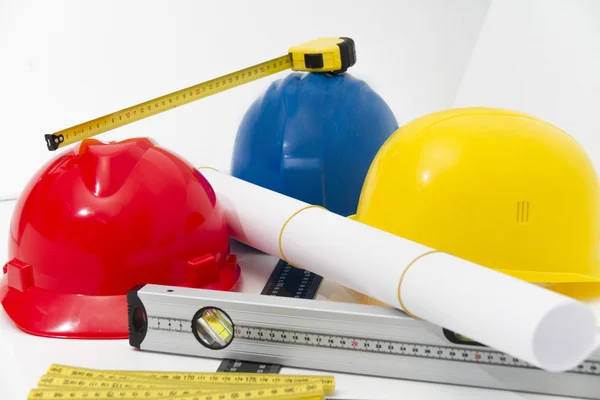 Colorful helmets and tools for construction drawings and buildin — Stock Photo, Image