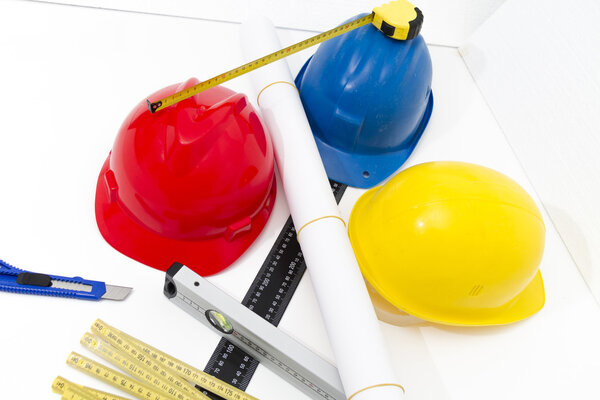 Colorful helmets and tools for construction drawings and buildin