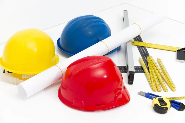 Colorful helmets and tools for construction drawings and buildin — Stock Photo, Image