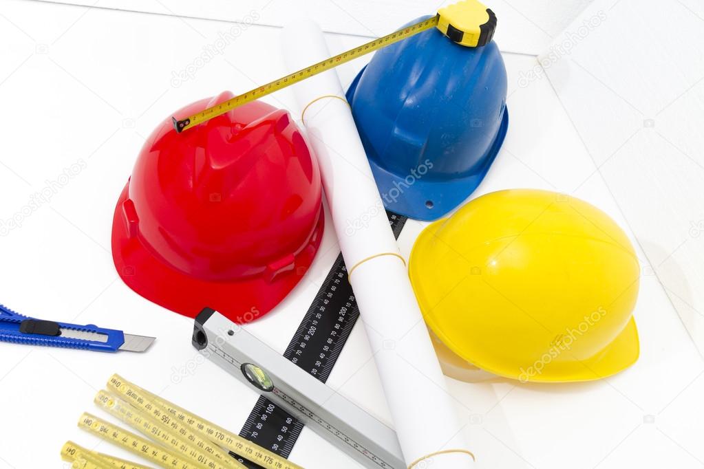 Colorful helmets and tools for construction drawings and buildin