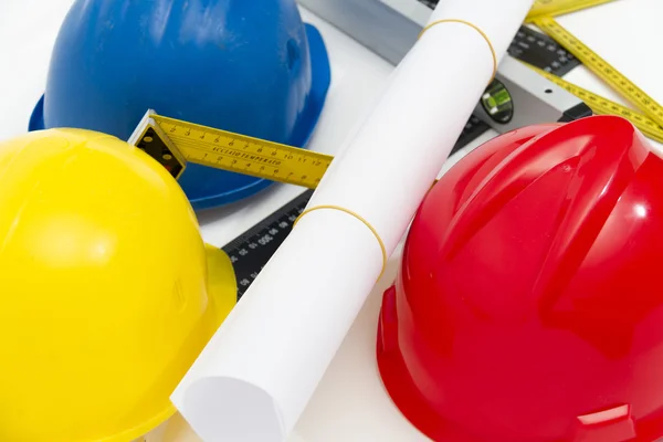 Colorful helmets and tools for construction drawings and buildin — Stock Photo, Image