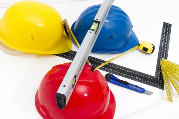 Разноцветные шлемы и инструменты для строительных чертежей и сборки — стоковое фото