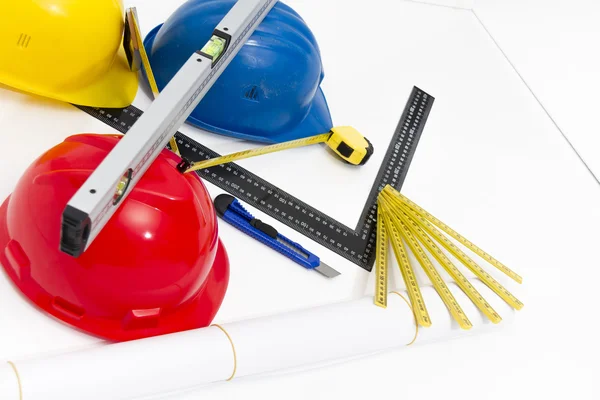 Colorful helmets and tools for construction drawings and buildin — Stock Photo, Image