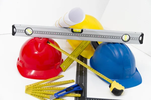 Casques et outils colorés pour les dessins de construction et la construction — Photo