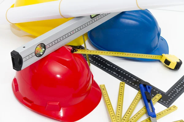 Colorful helmets and tools for construction drawings and buildin — Stock Photo, Image